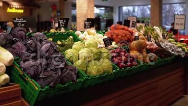 超市货架上有价格标签的新鲜蔬菜。 卷心菜，洋葱，土豆，南瓜在商店里出售。